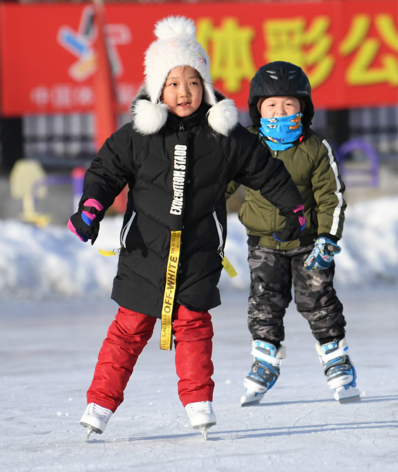 2月19日,两名小朋友在阿勒泰地区体委滑冰场学滑冰.